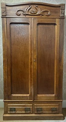 Antique American Golden Oak Two-Door Knockdown Wardrobe with Carved Crest and Drawers. This 