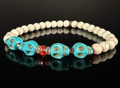 Silver and Beaded Stretch Bracelet Featuring Turquoise-Colored Skull Motifs. This stretch 