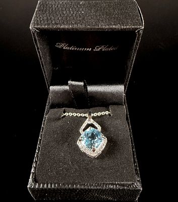 A Platinum Plated Aquamarine and Diamond Halo Pendant Necklace. This contemporary jewelry piece 