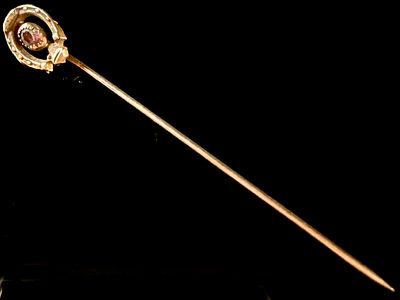 Victorian Style Horseshoe Stickpin with Purple-Red Gemstone. This stickpin features an 