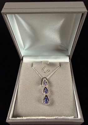 10 Karat Gold Blue Gemstone and Clear Accent Necklace. A 10 karat gold necklace and three-stone 