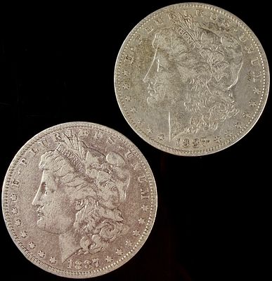 A Pair of US 1887-O Morgan Silver Dollars. This pair of US Morgan silver dollars consists of two 
