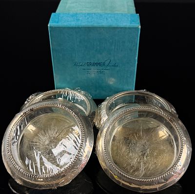 A Set of Four Sterling Silver and Glass Coasters. A set of four circular coasters featuring 