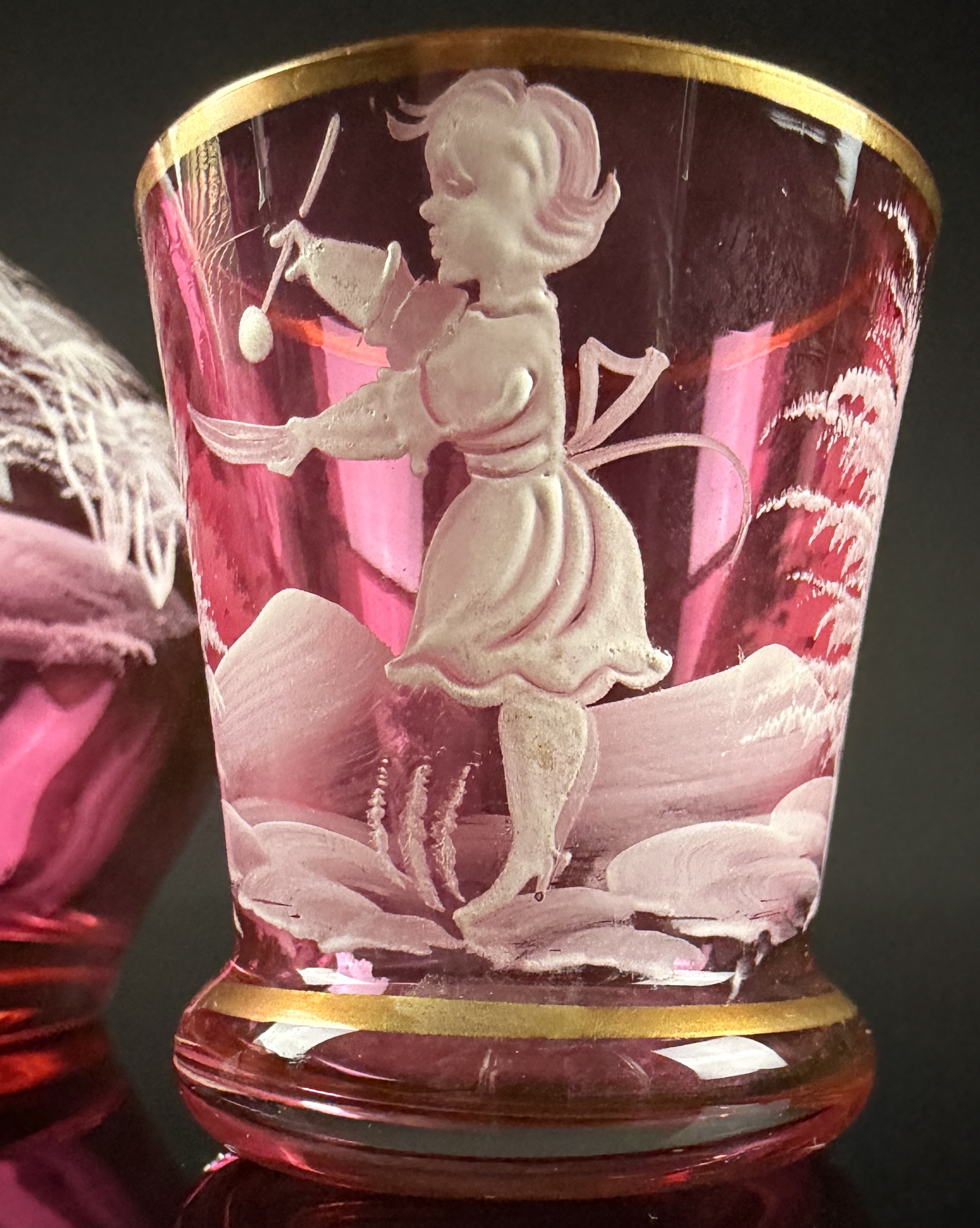 A Trio of Bohemian Mary Gregory Style Cranberry Glass Liqueur Decanter and Cordial Glasses