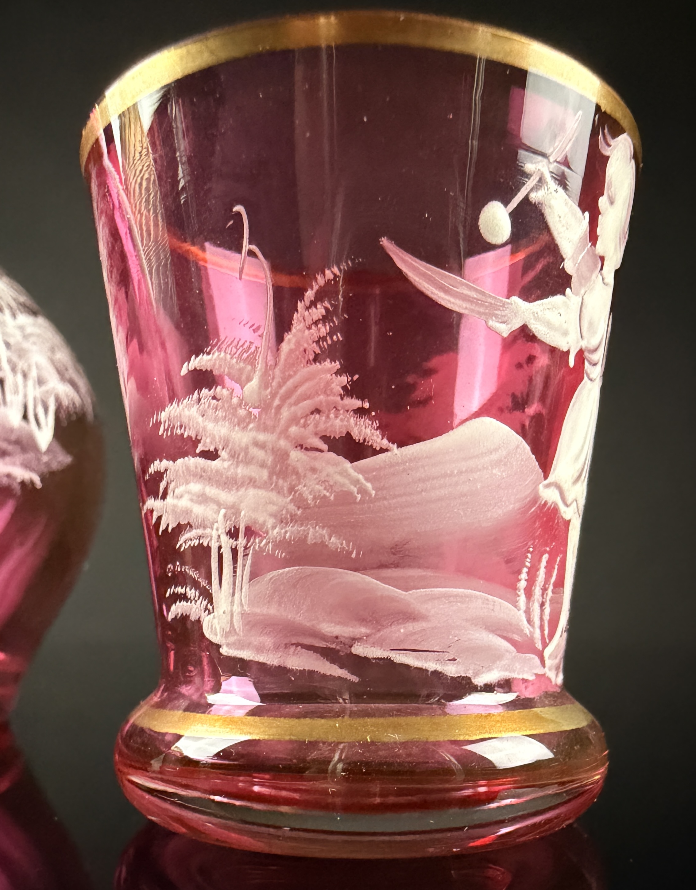 A Trio of Bohemian Mary Gregory Style Cranberry Glass Liqueur Decanter and Cordial Glasses