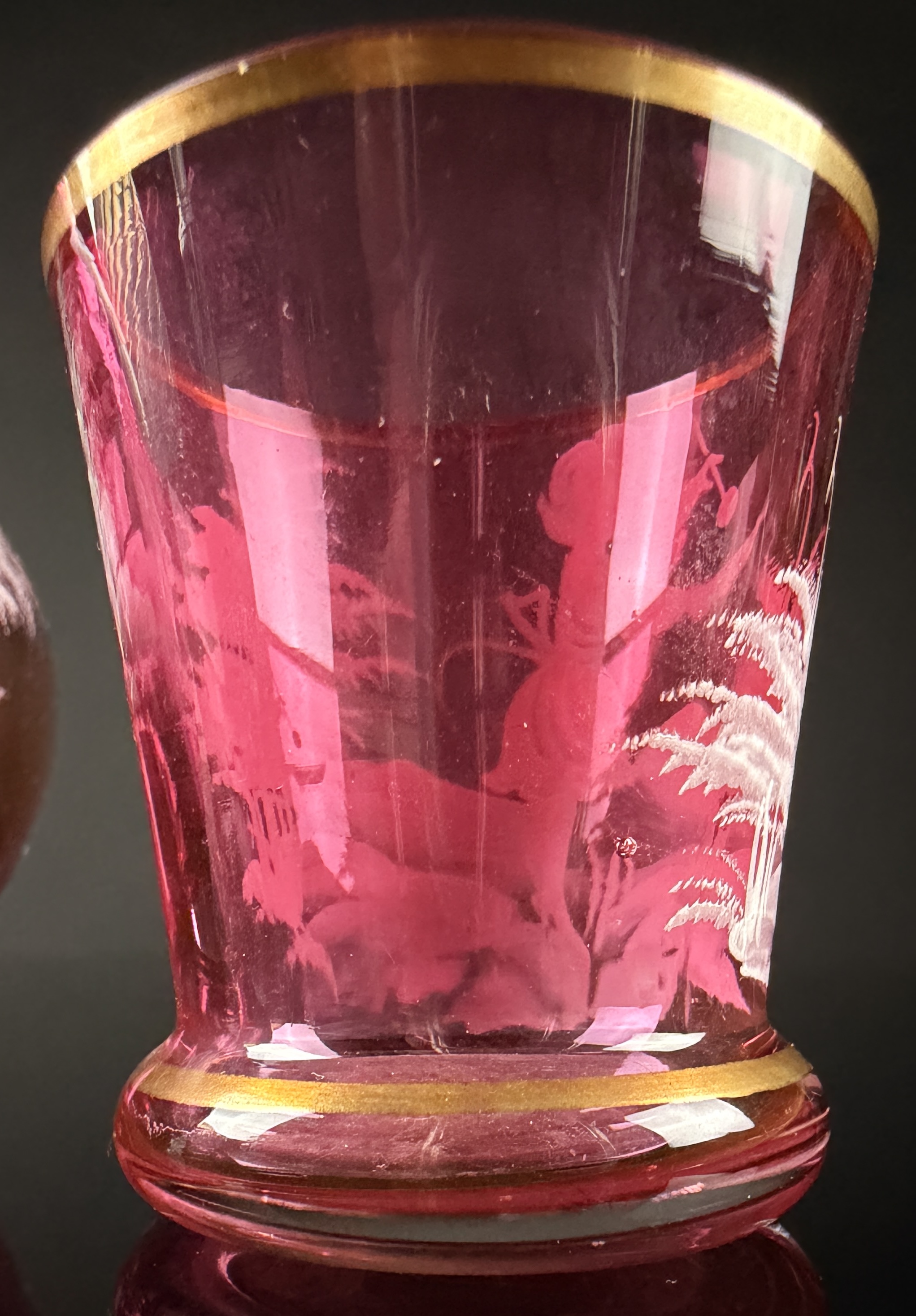 A Trio of Bohemian Mary Gregory Style Cranberry Glass Liqueur Decanter and Cordial Glasses