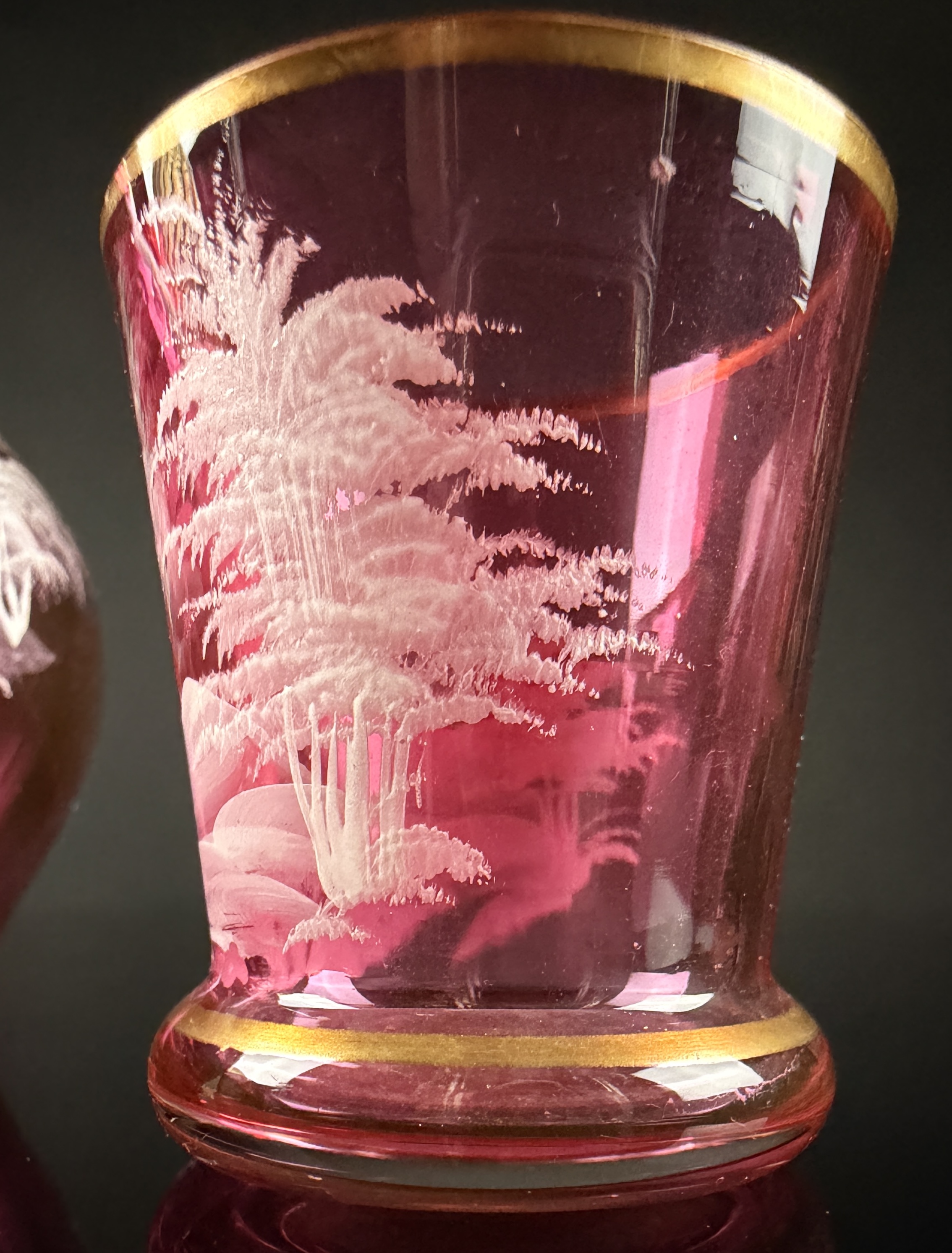 A Trio of Bohemian Mary Gregory Style Cranberry Glass Liqueur Decanter and Cordial Glasses