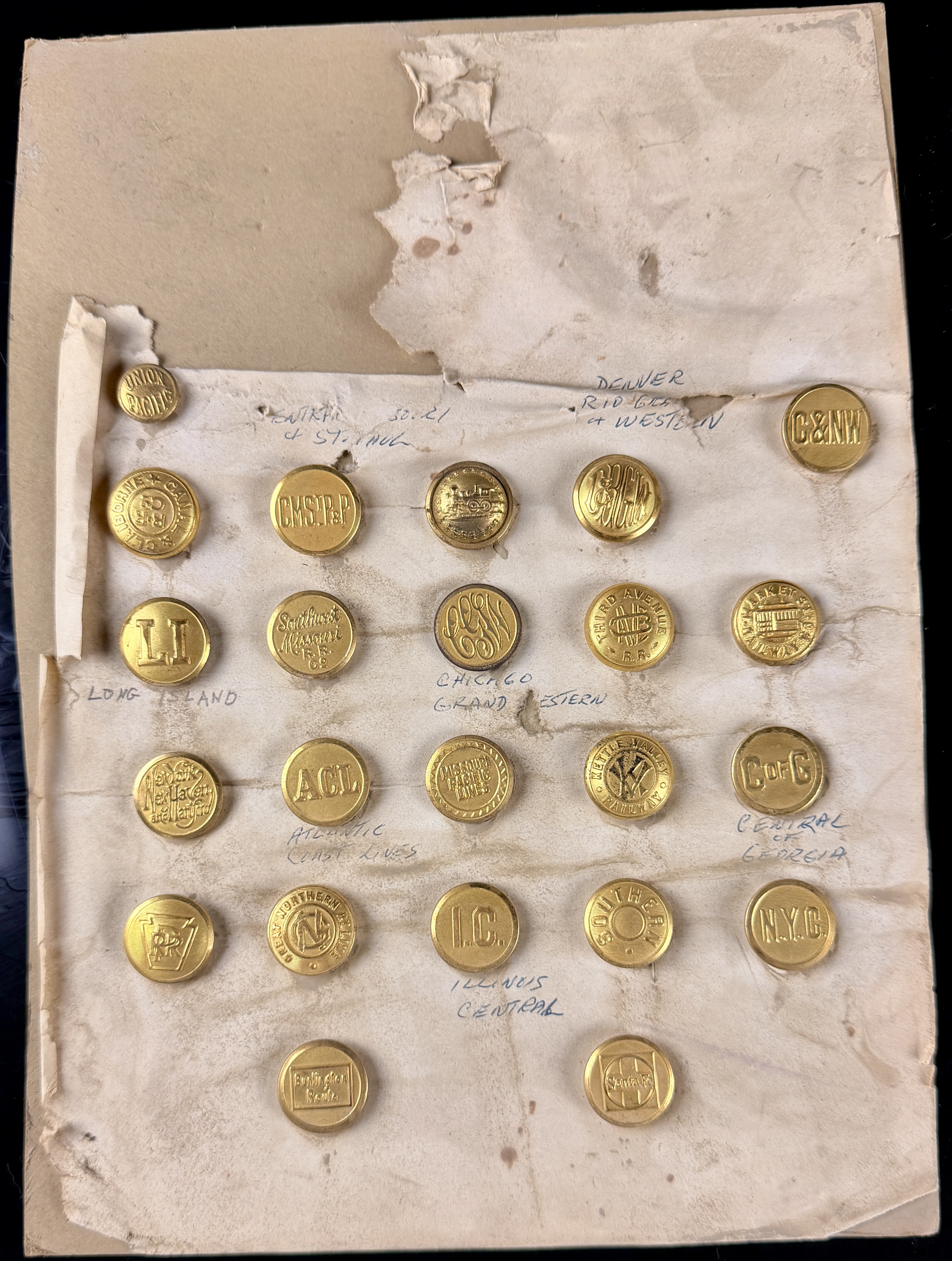 A Collection of 23 Vintage North American Railroad and Transit Uniform Buttons on Original Handwritten Mounting Card