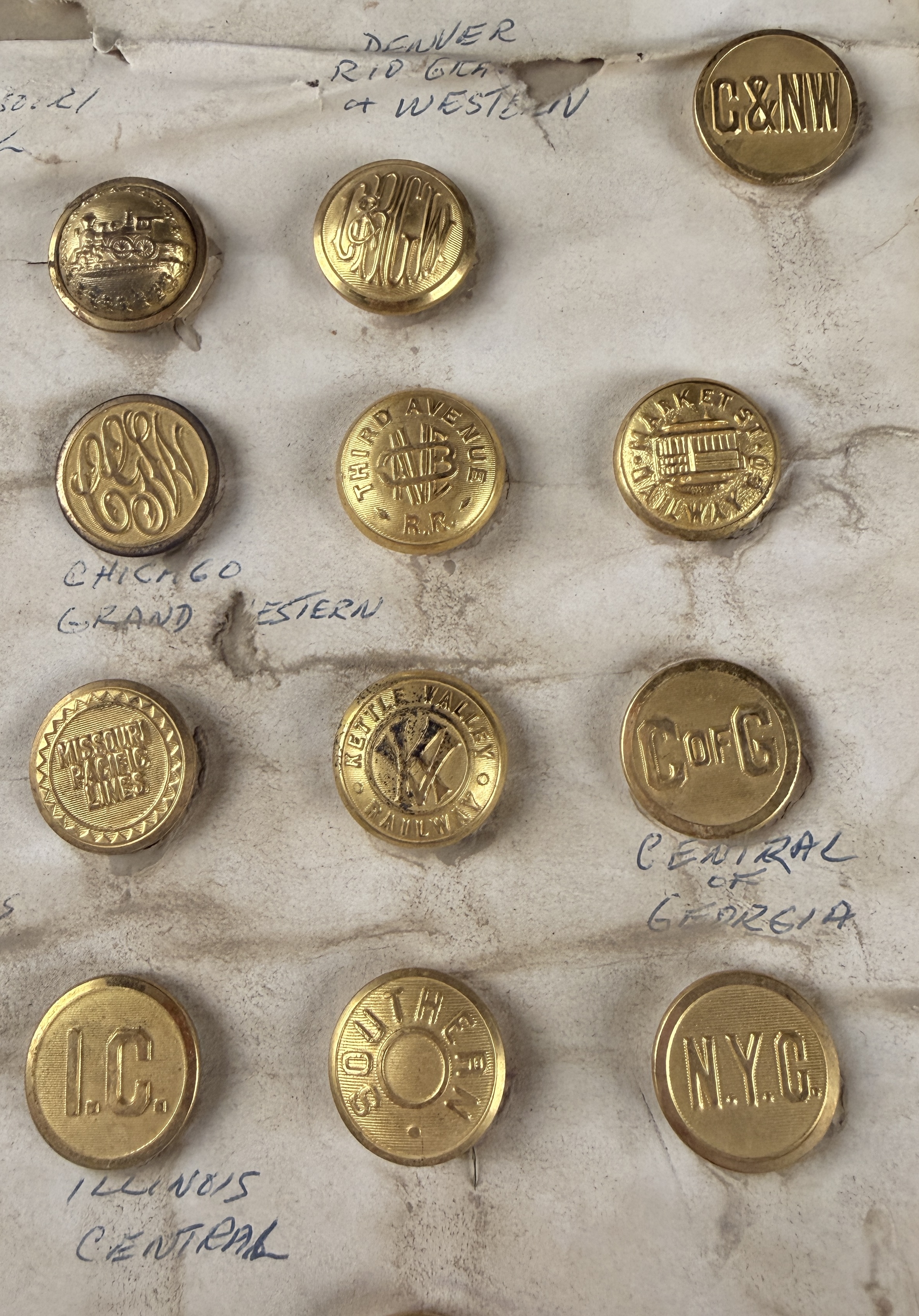 A Collection of 23 Vintage North American Railroad and Transit Uniform Buttons on Original Handwritten Mounting Card