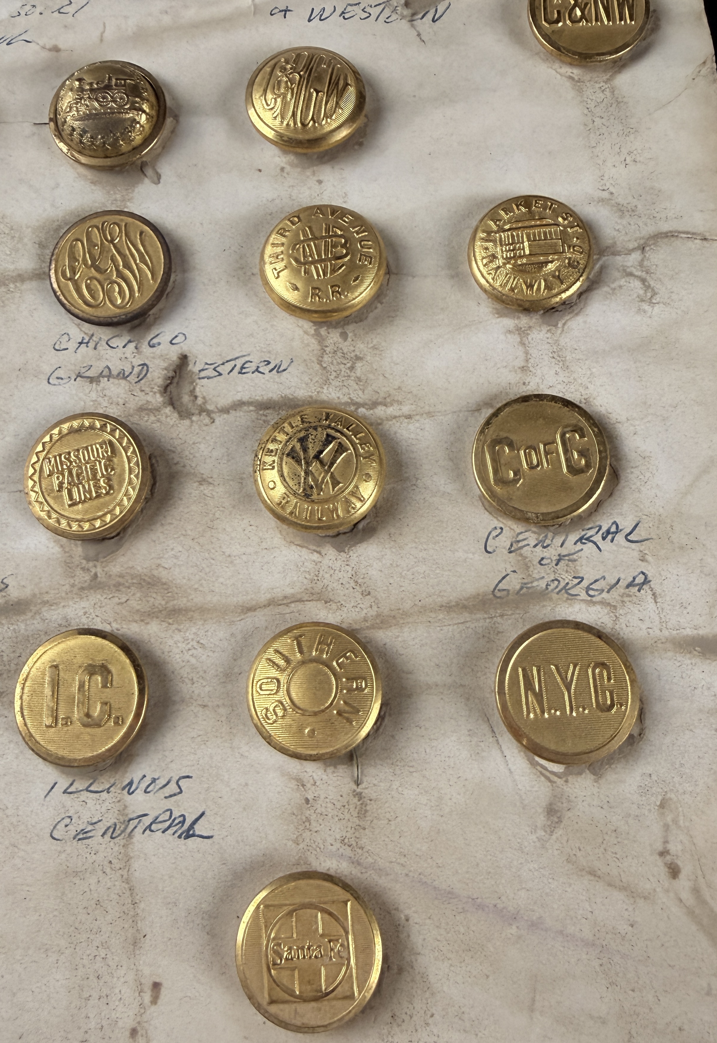 A Collection of 23 Vintage North American Railroad and Transit Uniform Buttons on Original Handwritten Mounting Card