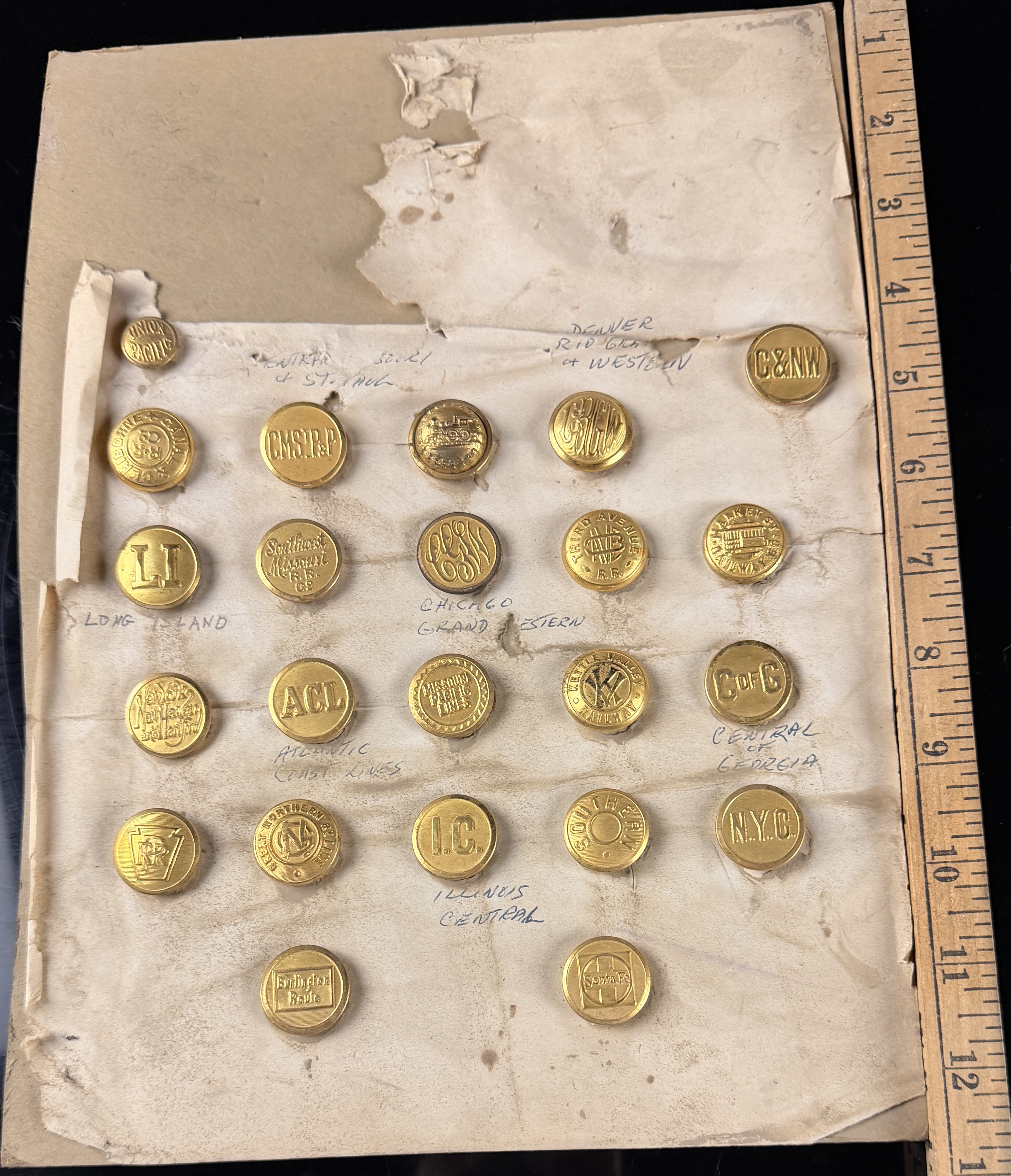 A Collection of 23 Vintage North American Railroad and Transit Uniform Buttons on Original Handwritten Mounting Card