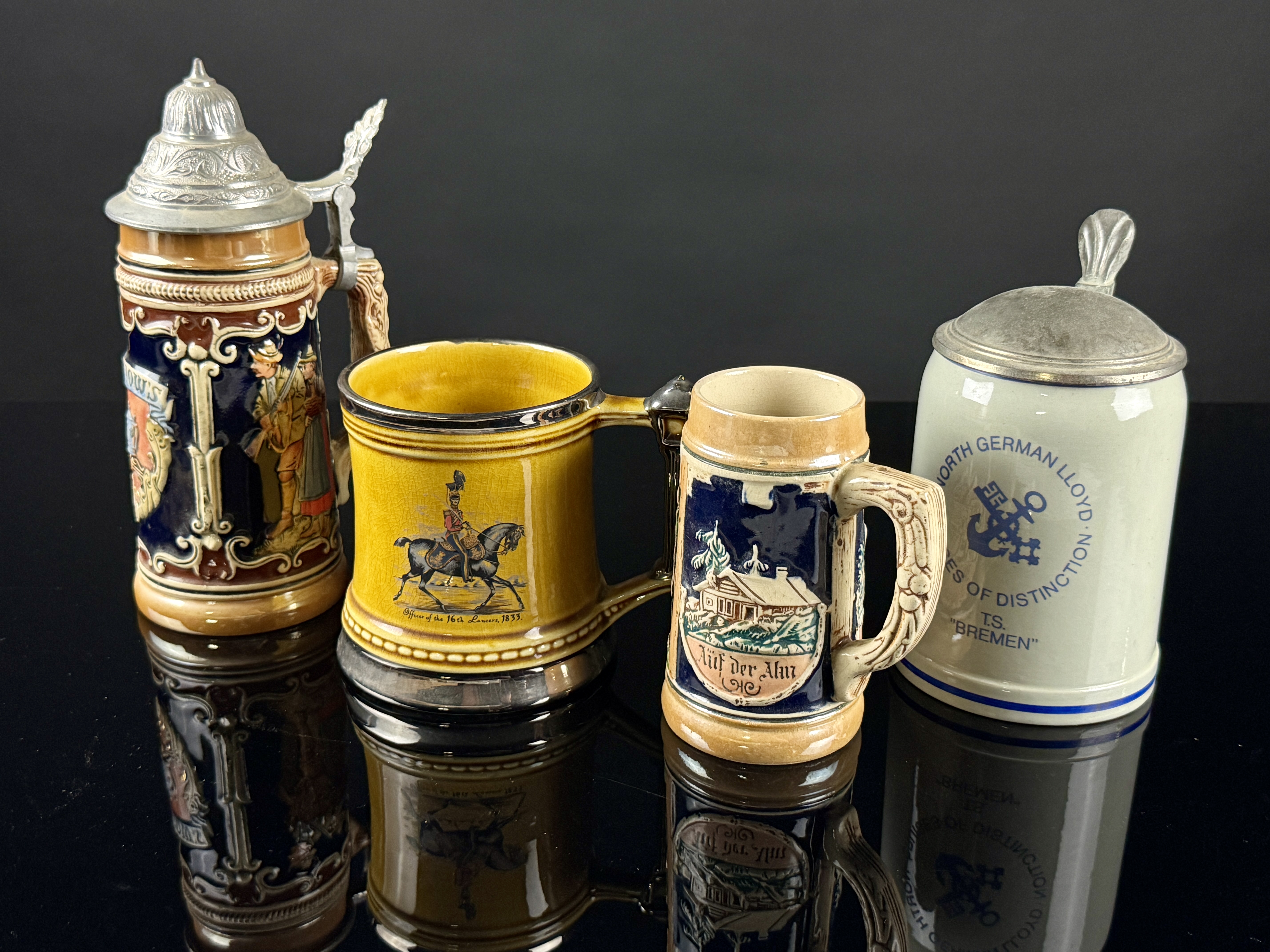 An Assortment of Four German and English Steins and Mugs