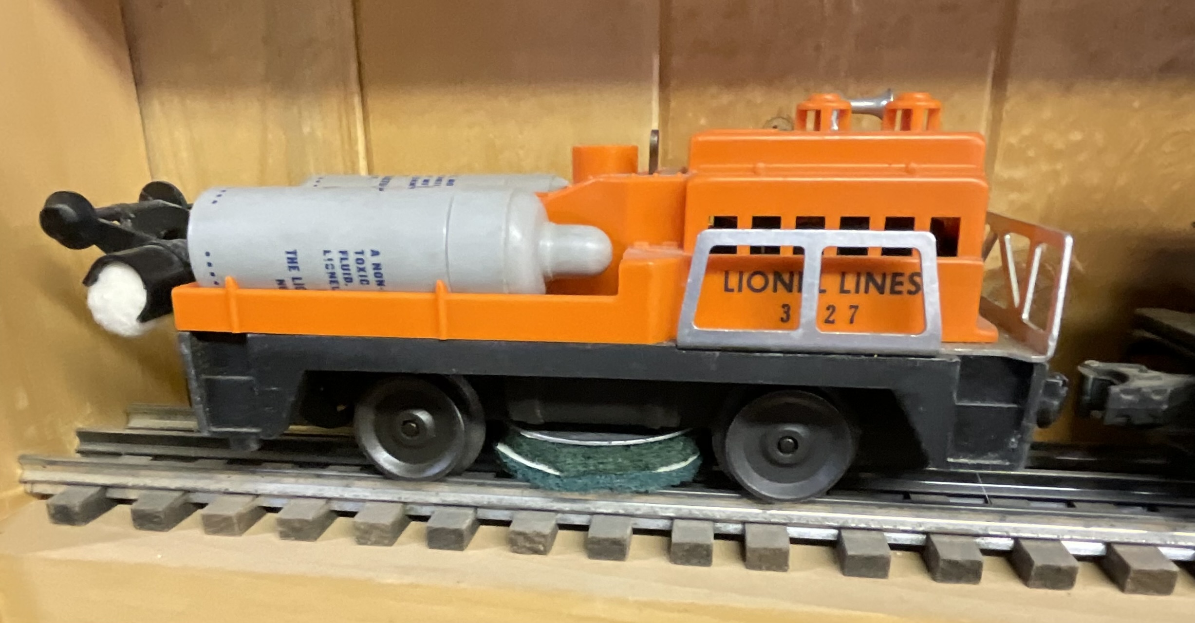 Three Lionel O-Gauge Model Train Pieces including 3927 Track Cleaning Car and 1615 Steam Locomotive with Tender