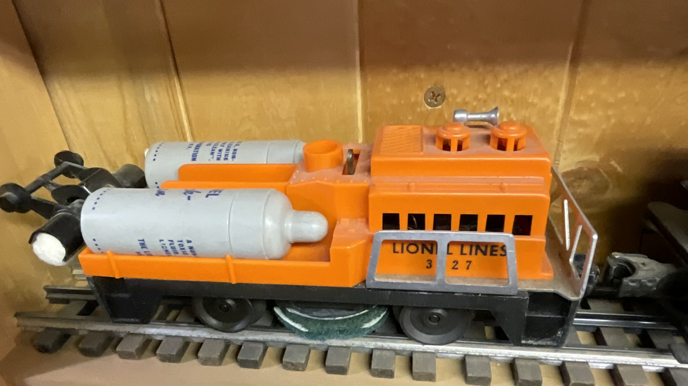 Three Lionel O-Gauge Model Train Pieces including 3927 Track Cleaning Car and 1615 Steam Locomotive with Tender