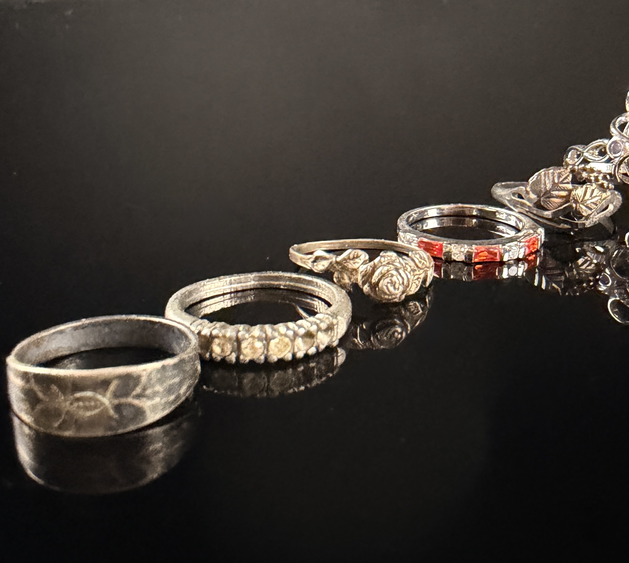 A Collection of Nine Sterling Silver Rings with Various Gemstones and Decorative Accents