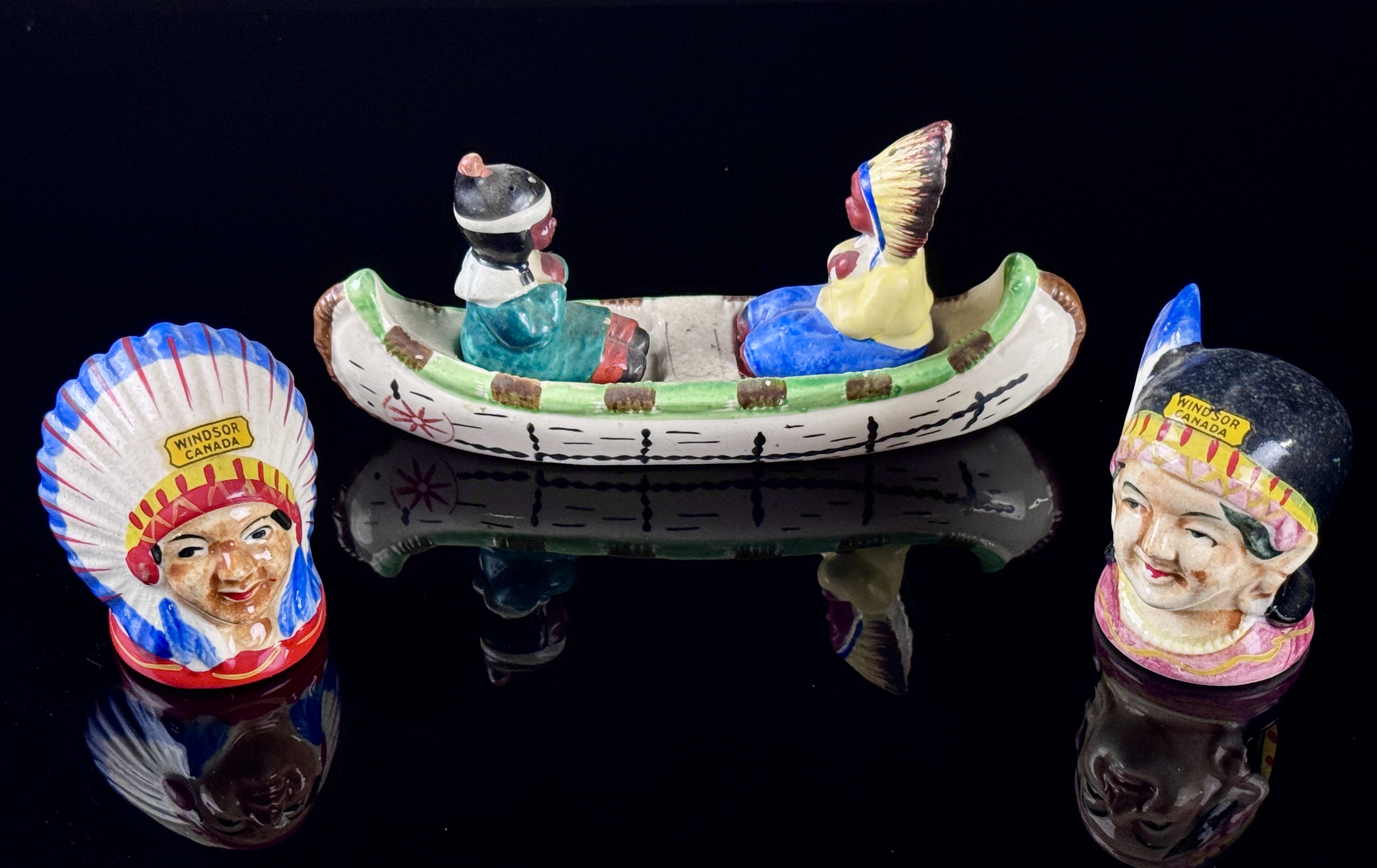A Set of Four Japanese Hand Painted Ceramic Native American Souvenir Salt and Pepper Shakers and Canoe Base