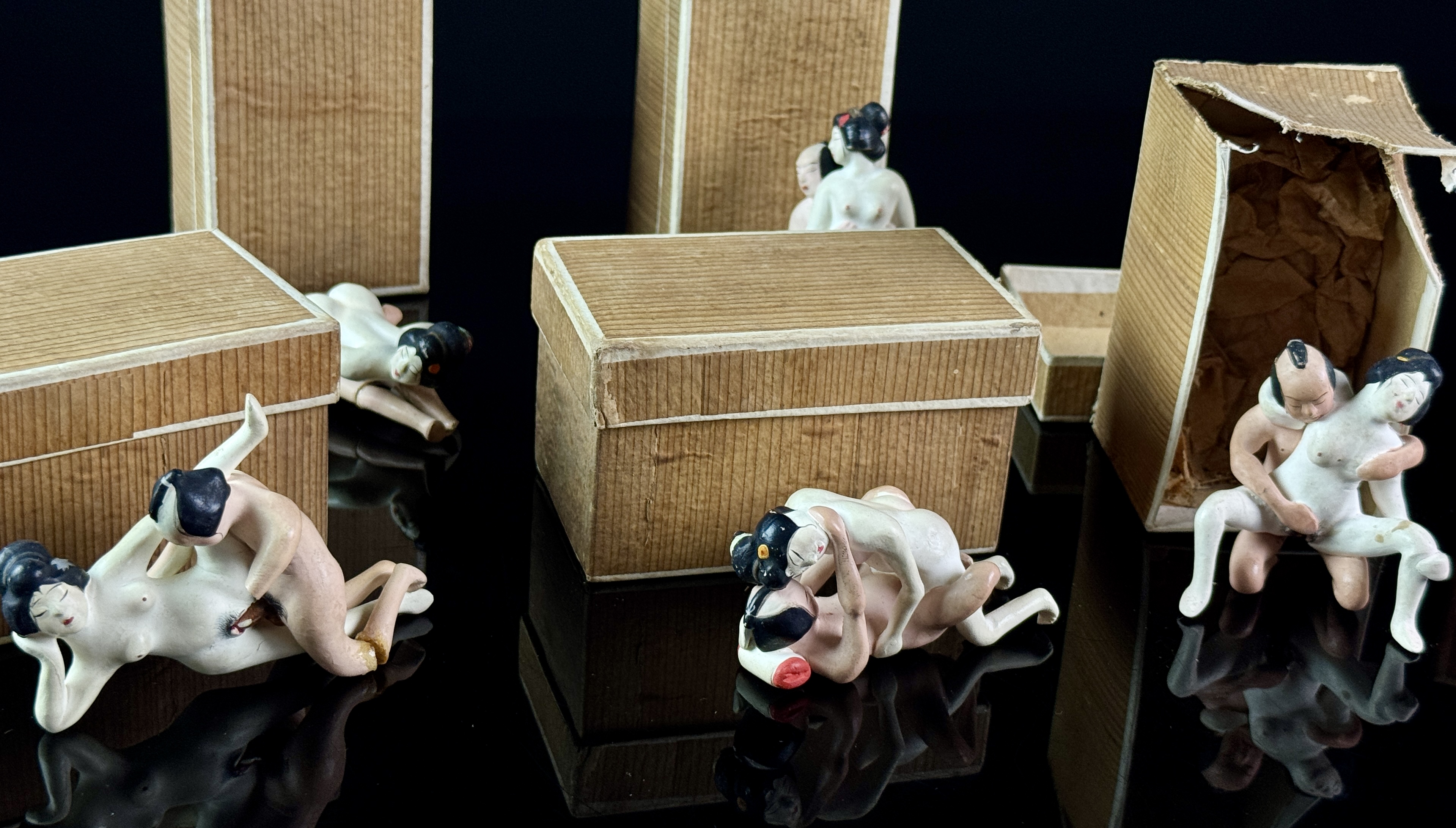 A Set of Six Miniature Hand-Painted Biscuit Porcelain Erotic Figural Groups in Boxes