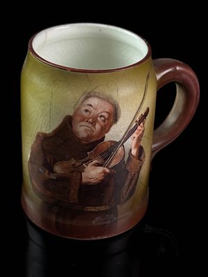 Morris and Willmore Co. Monk Playing Violin Glazed Ceramic Mug. A glazed ceramic mug featuring a 