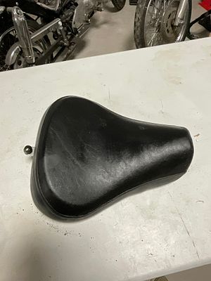 Solo Motorcycle Rider Seat with Chrome Mounting Bracket. A solo motorcycle rider seat featuring 
