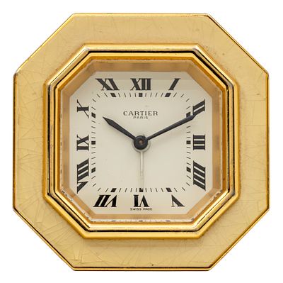 שעון שולחני מעורר Cartier. 
שעון מתומן, מסגרת מוזהבת עם אמייל לבן. 
מנגנון מכני, מצב עבודה 