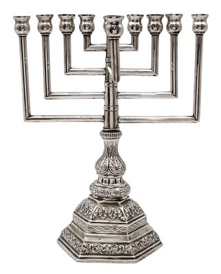 חנוכית כסף, גרמניה, תחילת המאה ה-20. 
בסיס משושה עם עיטורי עלים. 
חתום. 
גובה: 32ס"מ. 
רוחב: 