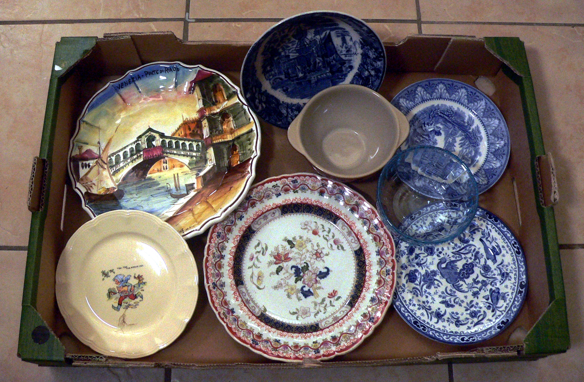 Box of misc. ceramic plates and a light blue glass bowl.