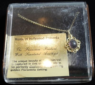 Necklace. Like new in box. Amethyst color gem with gold tone setting. Ronte of Hollywood Presents