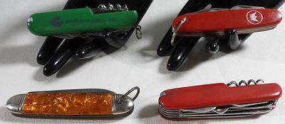 Multi-Tool Pocket Knives, Amber & Colored Handles. Collection of five multi-tool pocket knives 