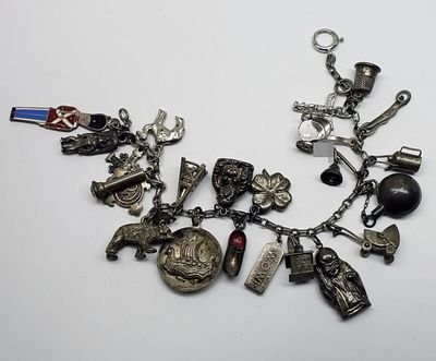 Sterling Charm Bracelet, 23 Charms. This marked sterling silver charm bracelet measures 7 inches 