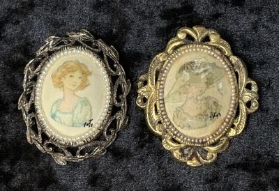 Portrait Cameo Brooches. Two miniature portrait brooches, each set within an ornate open-cut 