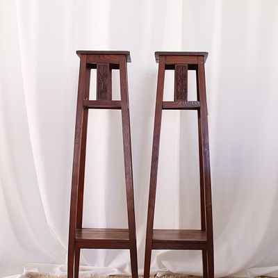 Par de colunas altas em madeira com ripados e decora&ccedil;&atilde;o em relevo, com motivos vegetalistas. 