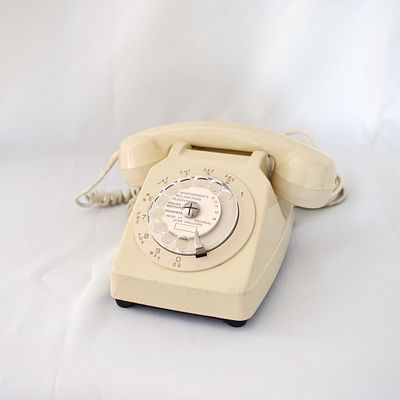 Telefone de disco vintage, de cor creme, que preserva a rota&ccedil;&atilde;o do disco sem problema. 