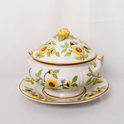 Conjunto de terrina com tampa e prato decorados com girass&oacute;is em alto relevo. Marcada no fundo 