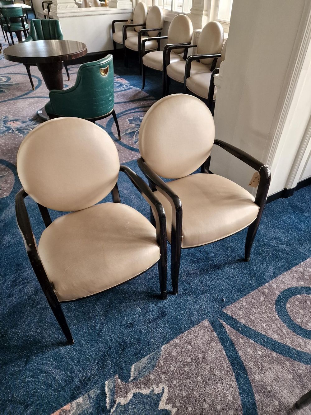 Lot 622: * A pair of French style round back armchairs upholstered in champagne gold leather the round back