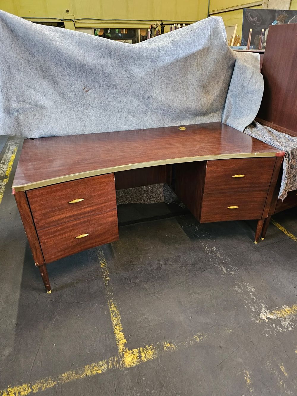 Lot 284: * Julian Chichester desk mahogany concave topped with brass edge trim two drawer with designer label