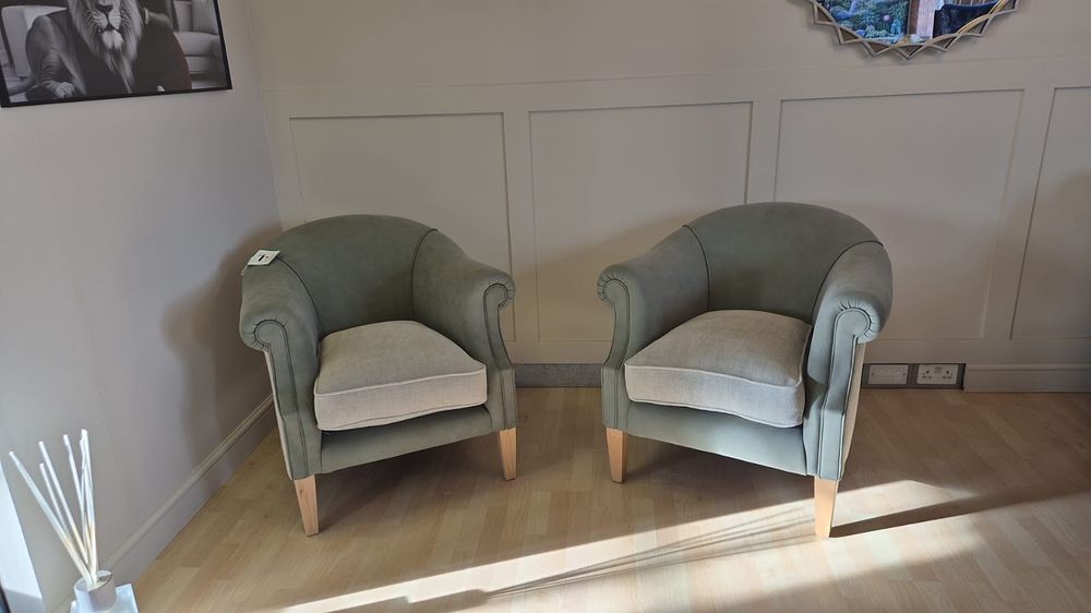 Lot 494: * A pair of leather and fabric armchairs characterised by its classic yet comfortable design
