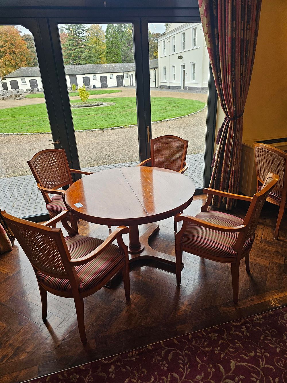 Lot 700: * A hardwood circular dining table on pedestal 115 x 73cm complete with 4 x cane back upholstered