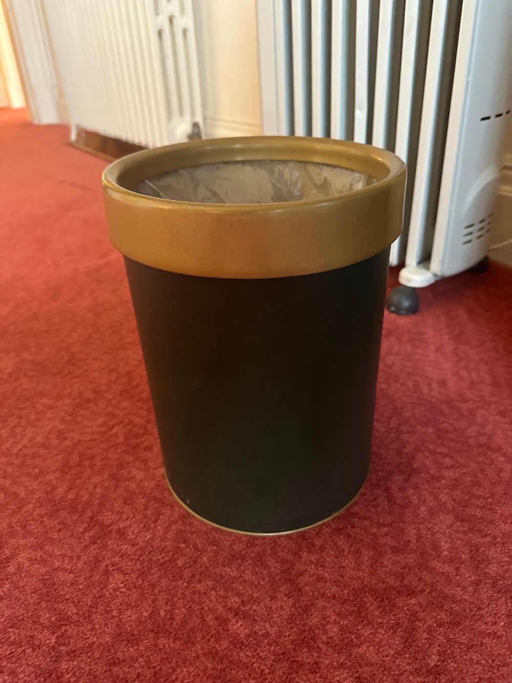 Lot 1405: * A cylindrical wastebasket or bin features a grey black body with a contrasting golden or