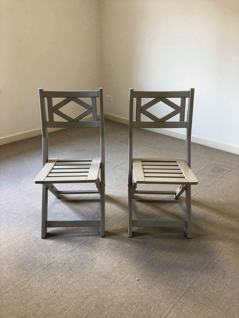 Lot 280: A pair of light grey painted folding wooden patio or bistro chairs measuring 36 x 36 x 83 {cm}.