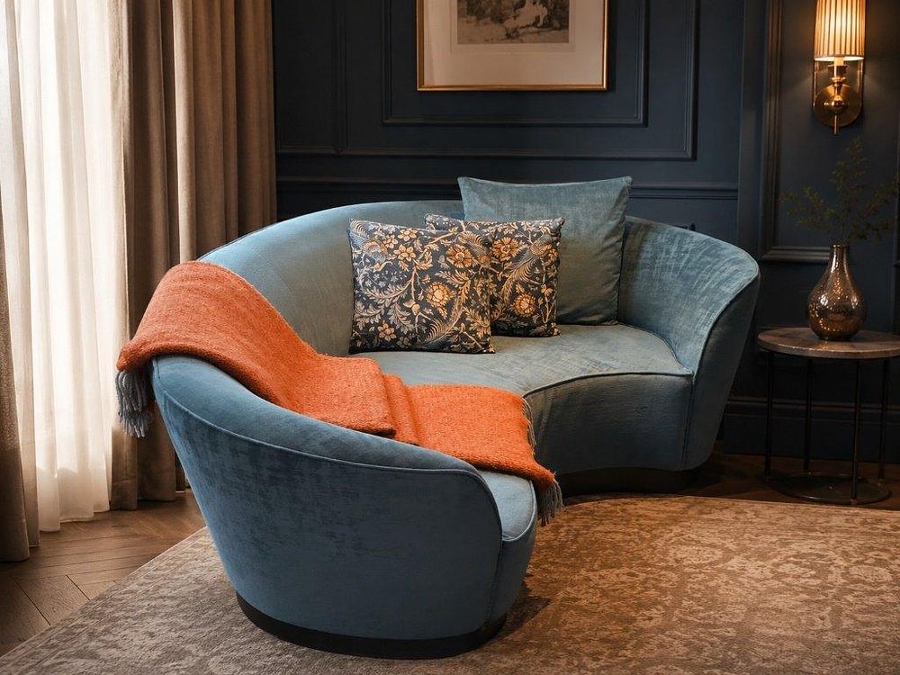 Lot 1083: A contemporary teal blue crescent-shaped curved sofa