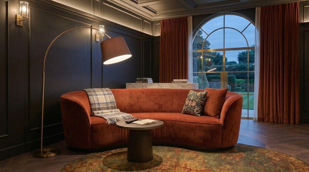 Lot 1093: A contemporary terracotta rust crescent-shaped curved sofa