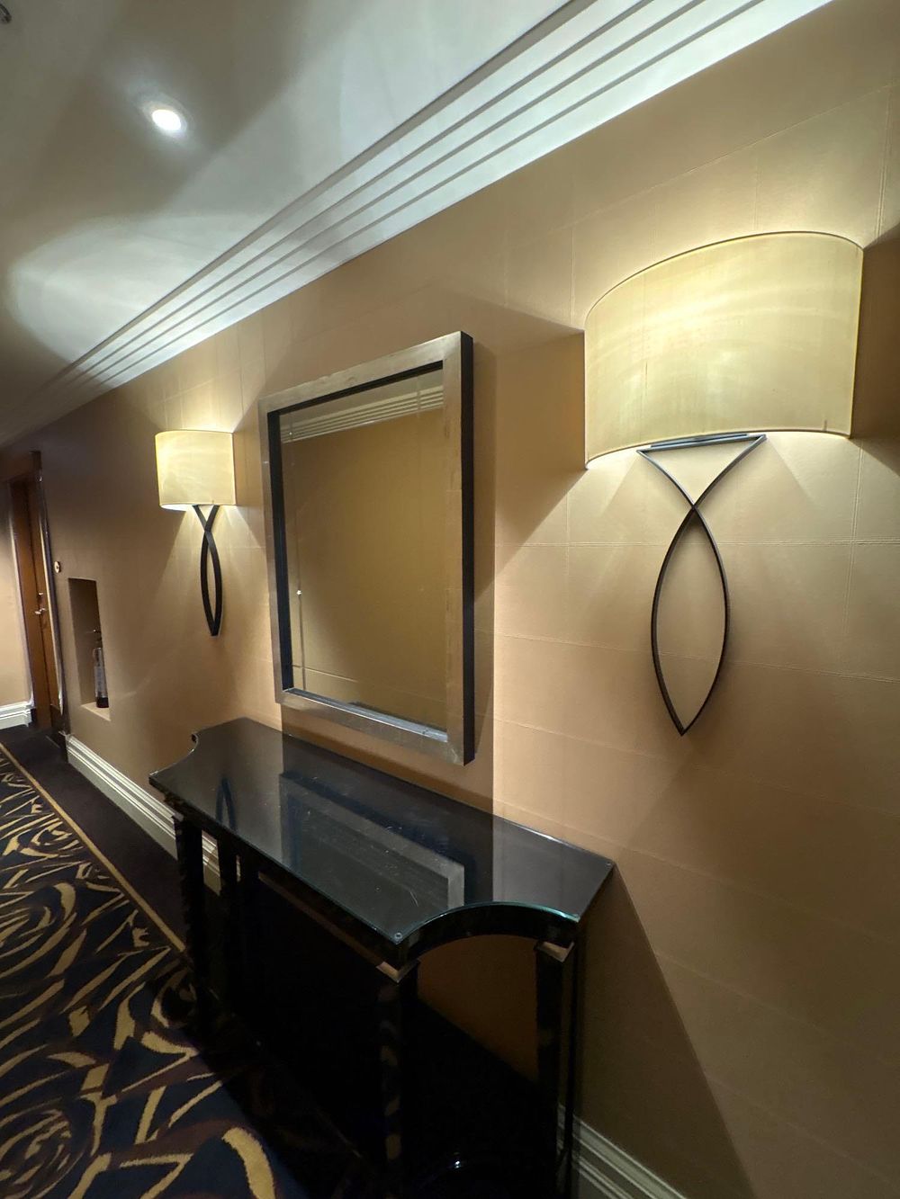 Lot 2048: A pair of wall lamps feature a sculpted base, crafted from forged metal