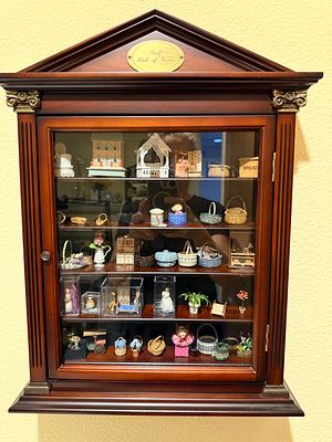 An Assortment of Miniature Dollhouse Accessories and Figurines in a Repurposed Wall-Mounted 