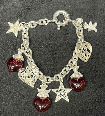 Signed Vintage Kirks Folly Silver Tone Heart Star And Cherub Charm Bracelet. This lot contains a 