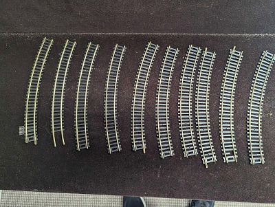 Assorted HO Scale Atlas AHM Lionel Curved Tracks. This lot includes: 
(9) AHM 2560 Tracks. Each 