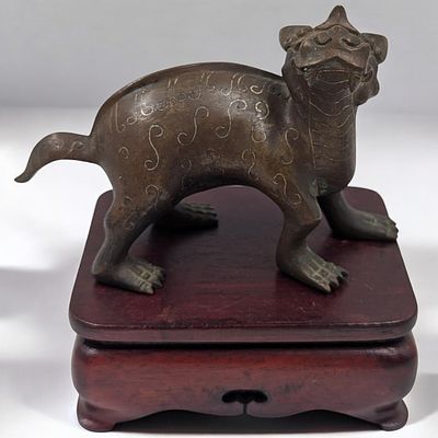 An Early Chinese Bronze Feng Shui Qilin On A Wooden Stand. Measures approx. 5" X 4 1/2" with 