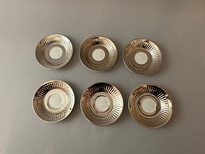 A set of six Royal Worcester porcelain saucers. Each saucer features a highly reflective 
