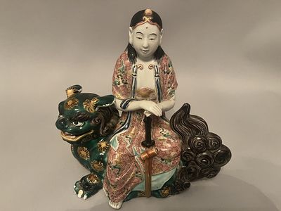 A Japanese Meiji Period Kutani porcelain figure of Kannon on Shishi. This glazed ceramic 