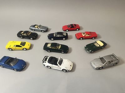 A collection of eleven die-cast model cars, predominantly representing luxury and sports 