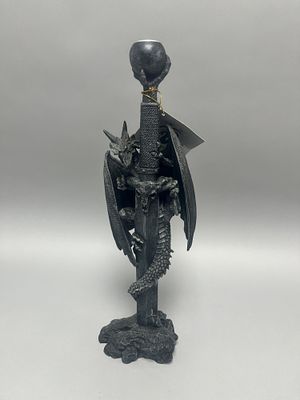 A dark grey/black dragon and sword-themed candlestick holder with a silver-toned candle cup 